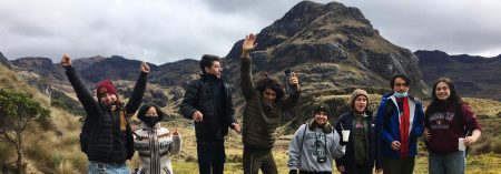 students standing in the mountains and some are jumping
