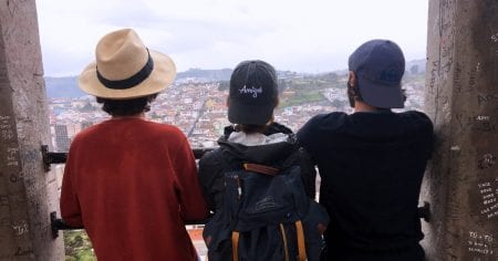 three people looking out over a city