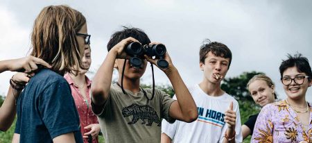 Several students in Panama, one looking through binoculars