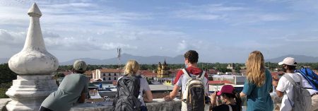 five students looking at a view of a city from a rooftop