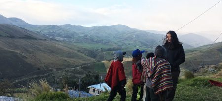 several children talk to an AMIGOS volunteer outside in Ecuador