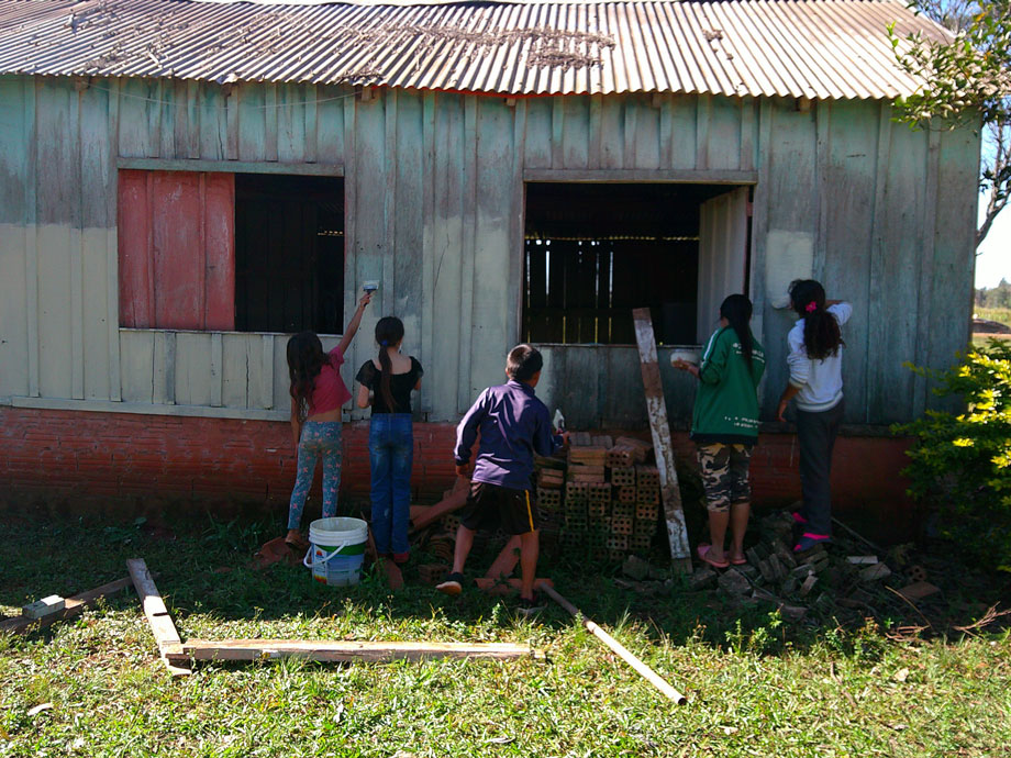 Kids painting the side of a barn