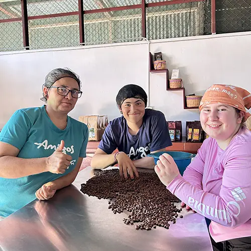 Volunteer sorting coffee beans with community members
