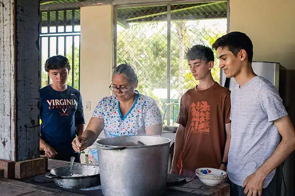 Volunteers cooking with local community member