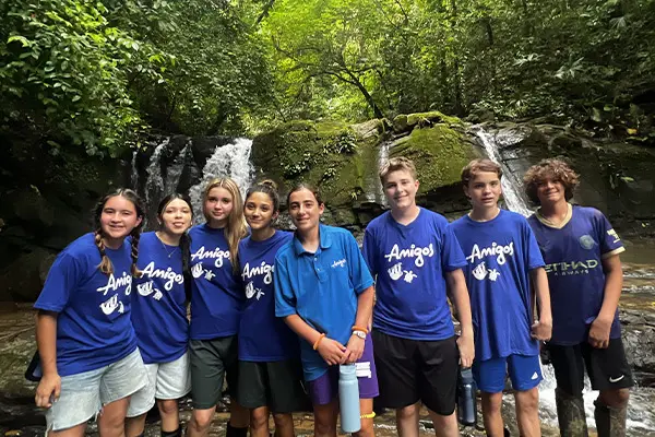 Group of volunteers in front of a waterfall