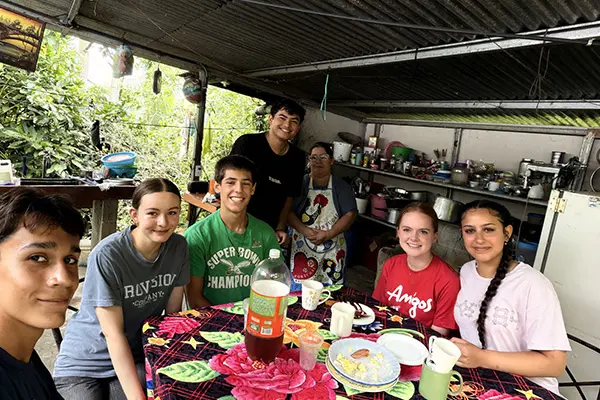 Volunteers sharing a meat at a host family house
