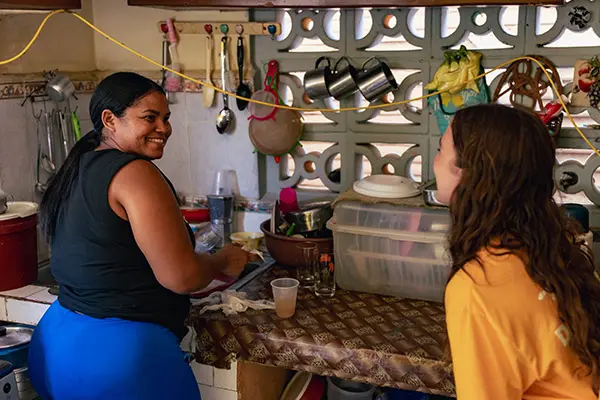 Volunteer chatting and laughing with host mom in the kitchen