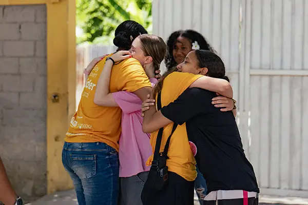 AMIGOS volunteers and local youth merging into a hug