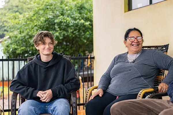 Volunteer sitting and smiling alongside his local host mom