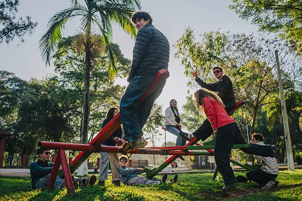 Volunteers playing on playground equipment in a sunny park