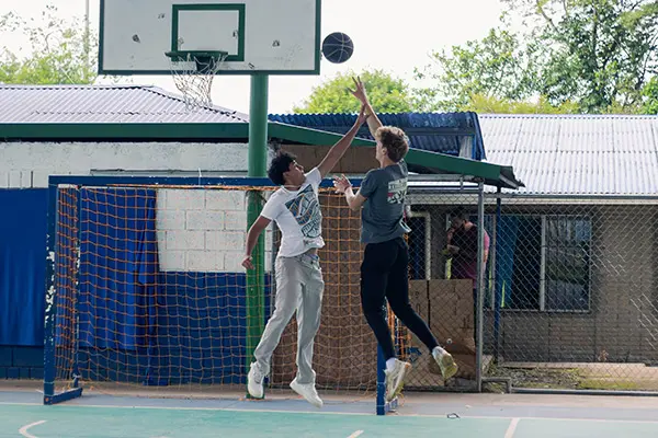 Volunteer and local youth playing basketball