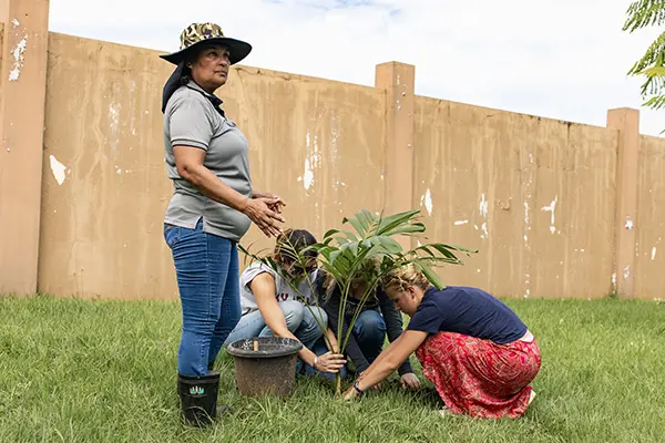 Volunteers doing service work with local community member leading