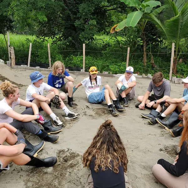 Volunteers sitting in a circle taking a break at a work site
