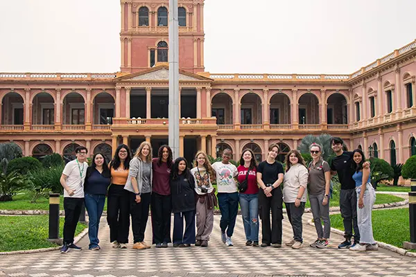 Volunteers posing together outside the presidential palace during a cultural city tour in Asunción