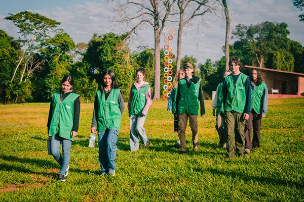 Volunteers walking in a line through a grassy open area of the natural reserve