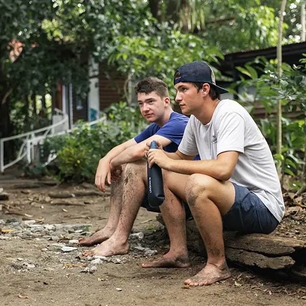 Volunteers taking a rest break with a water bottle after working outside