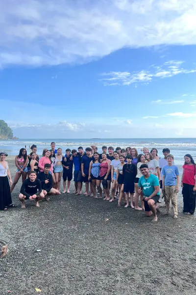 Large group of volunteers posing together on a beach