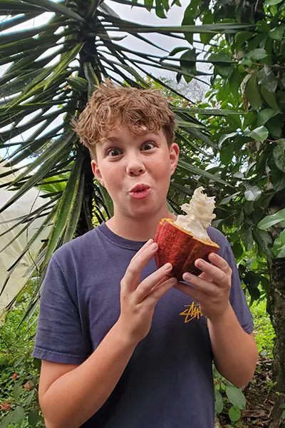 Smiling volunteer holding an open cacao pod