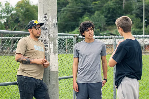 Volunteers talking together near an outdoor sports field