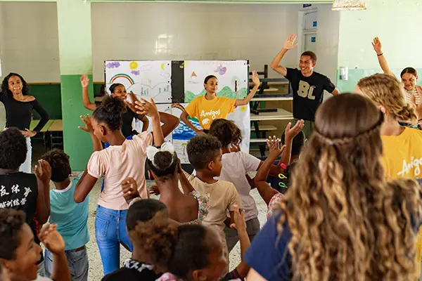Volunteers and local youth leading a dance for kids
