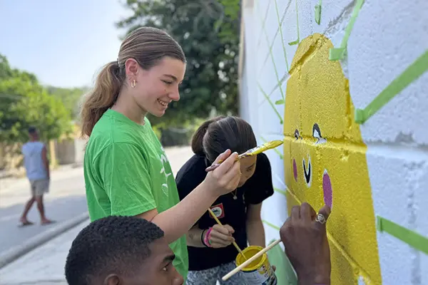 AMIGOS volunteer painting a mural