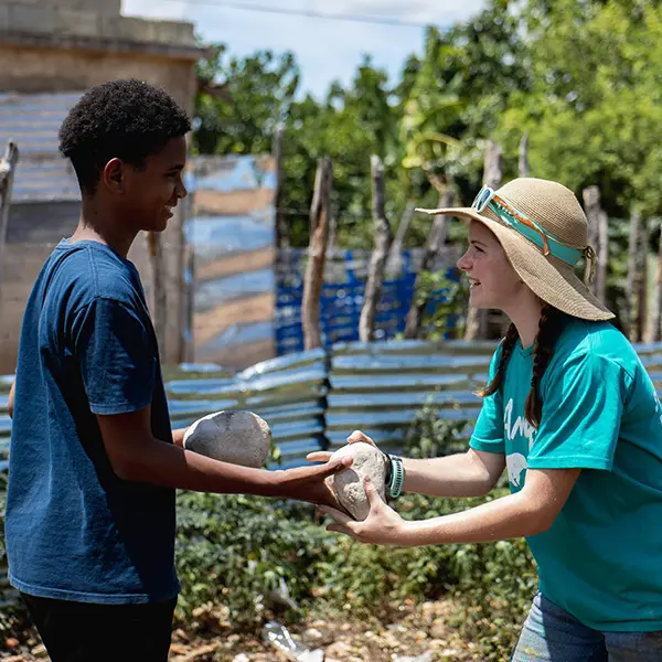 Volunteer and local youth working together on a community construction project