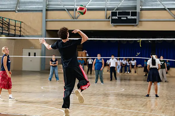 Volunteers playing volleyball with youth from a local high-school