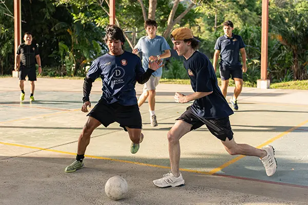 Volunteer playing soccer with local youth