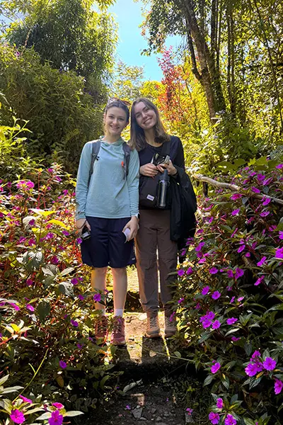 Volunteers walking on a path surrounded by flowers