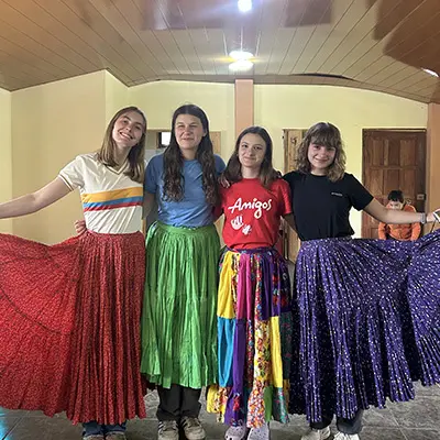 Smiling volunteers posing in colorful traditional skirts