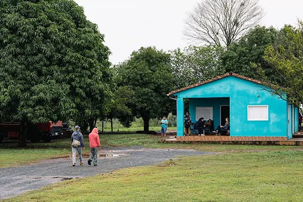 Volunteers walking near a bright blue house in a rural community