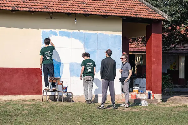 Volunteers painting a mural