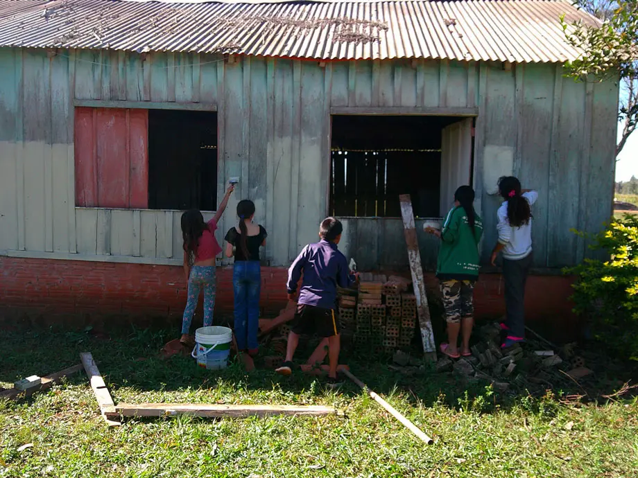 Kids painting the side of a barn